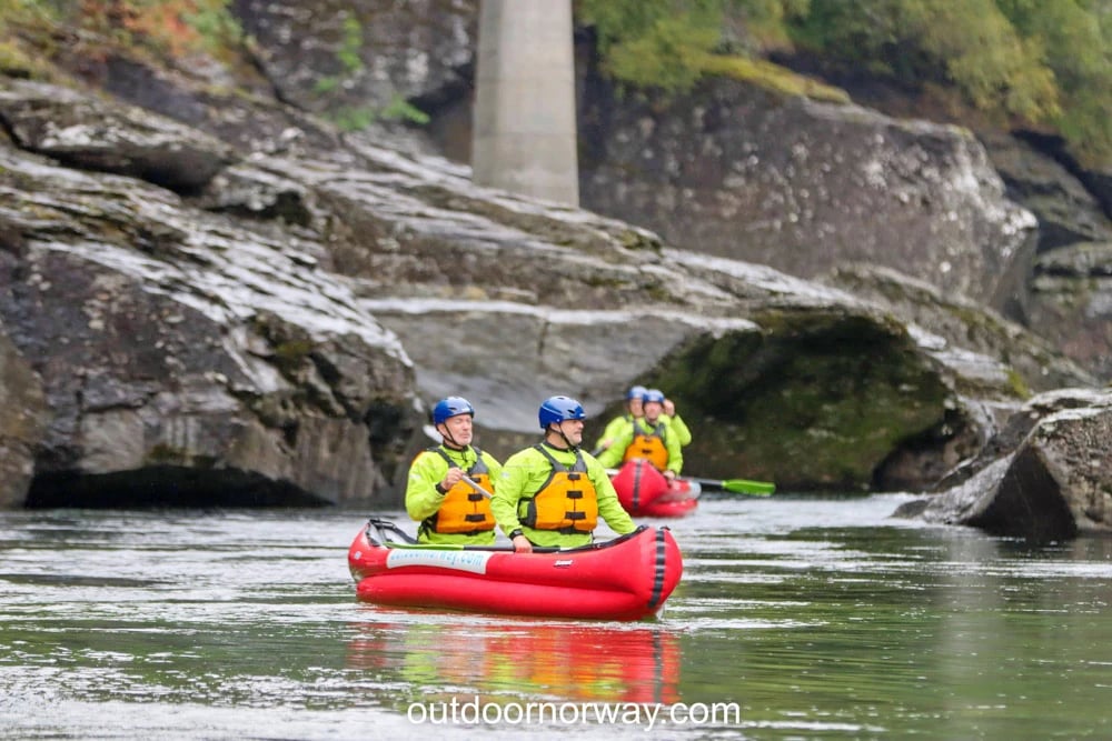 Group canoeing through rocky river